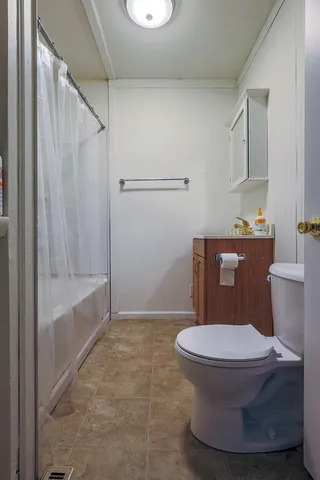 a bathroom with a toilet and a shower