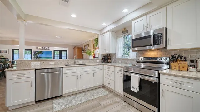 a kitchen with granite countertop a refrigerator cabinets and wooden floor