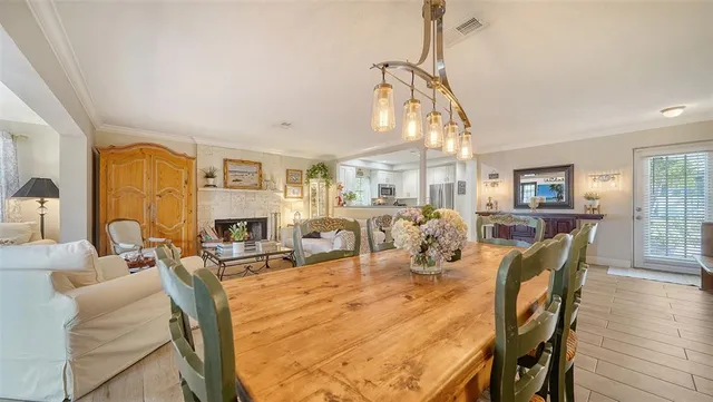 a living room with furniture and a dining table with wooden floor