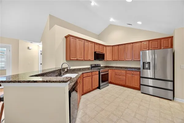 a kitchen with stainless steel appliances granite countertop a refrigerator sink and cabinets