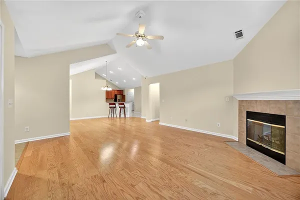 a view of a livingroom with a fireplace a chandelier and wooden floor