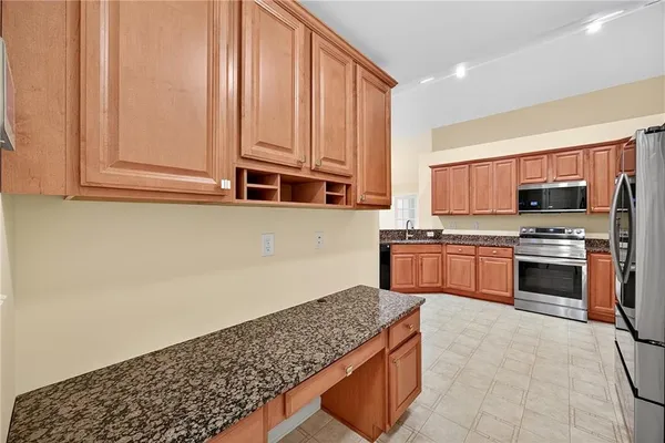a kitchen with stainless steel appliances granite countertop a stove a sink and a microwave