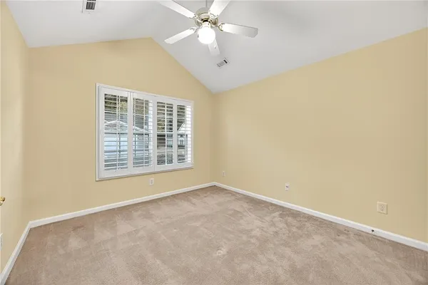 an empty room with a window and a ceiling fan