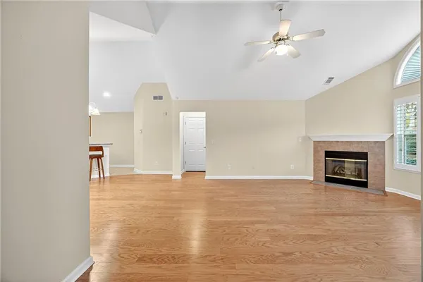 a view of an empty room with a fireplace and a window