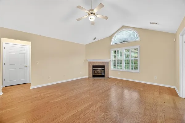 an empty room with windows and a ceiling fan