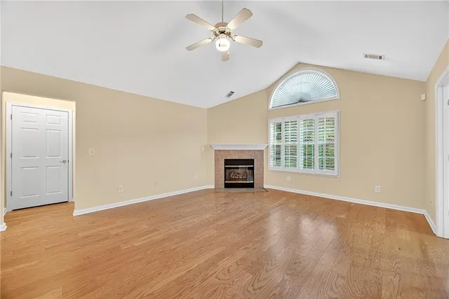 a view of livingroom with fireplace ceiling fan and window