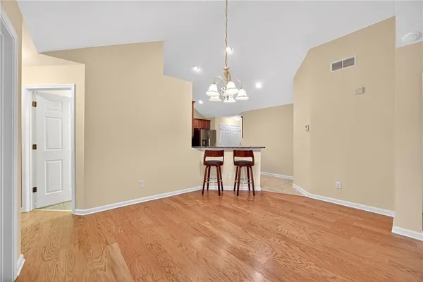 a view of a livingroom with a chandelier furniture and wooden floor
