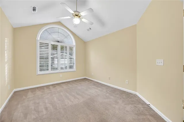 an empty room with a ceiling fan and a window