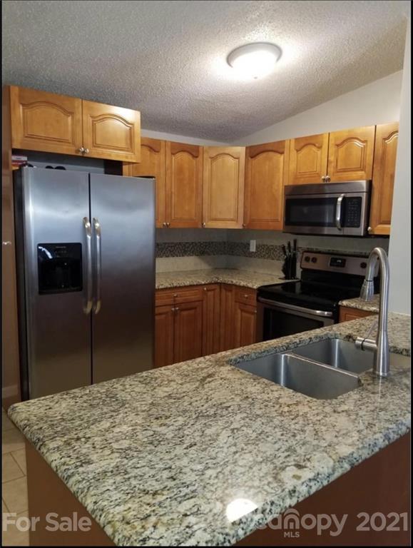 2924 Robinson Road Newton, NC 28658 - Photo 3 of 3 a kitchen with stainless steel appliances granite countertop a sink stove and refrigerator
