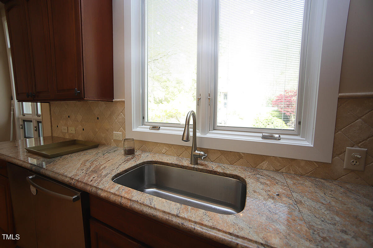 1108 Hymettus Court Raleigh, NC 27607 - Photo 8 of 48 a kitchen with granite countertop a sink window and cabinets