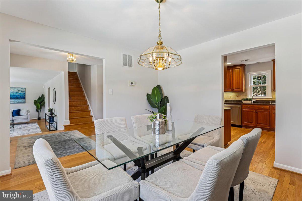 3105 Miller Heights Road Oakton, VA 22124 - Photo 26 of 60 a dining room with furniture a chandelier and wooden floor