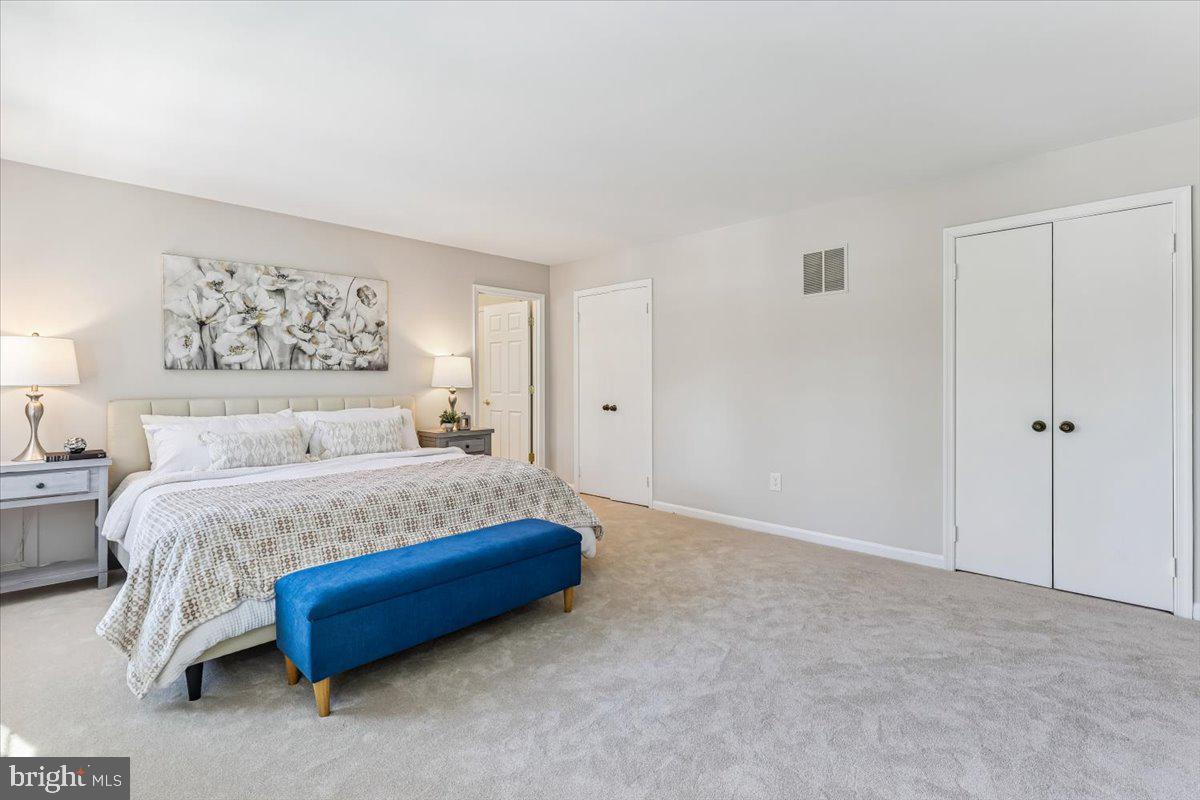 3105 Miller Heights Road Oakton, VA 22124 - Photo 31 of 60 a spacious bedroom with a bed and a painting on the wall