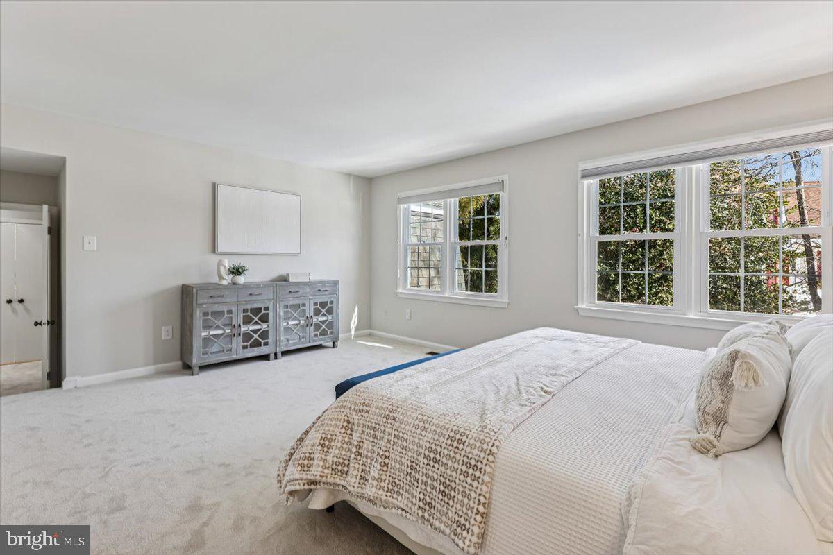 3105 Miller Heights Road Oakton, VA 22124 - Photo 32 of 60 a spacious bedroom with a bed a couch and a dresser next to a window