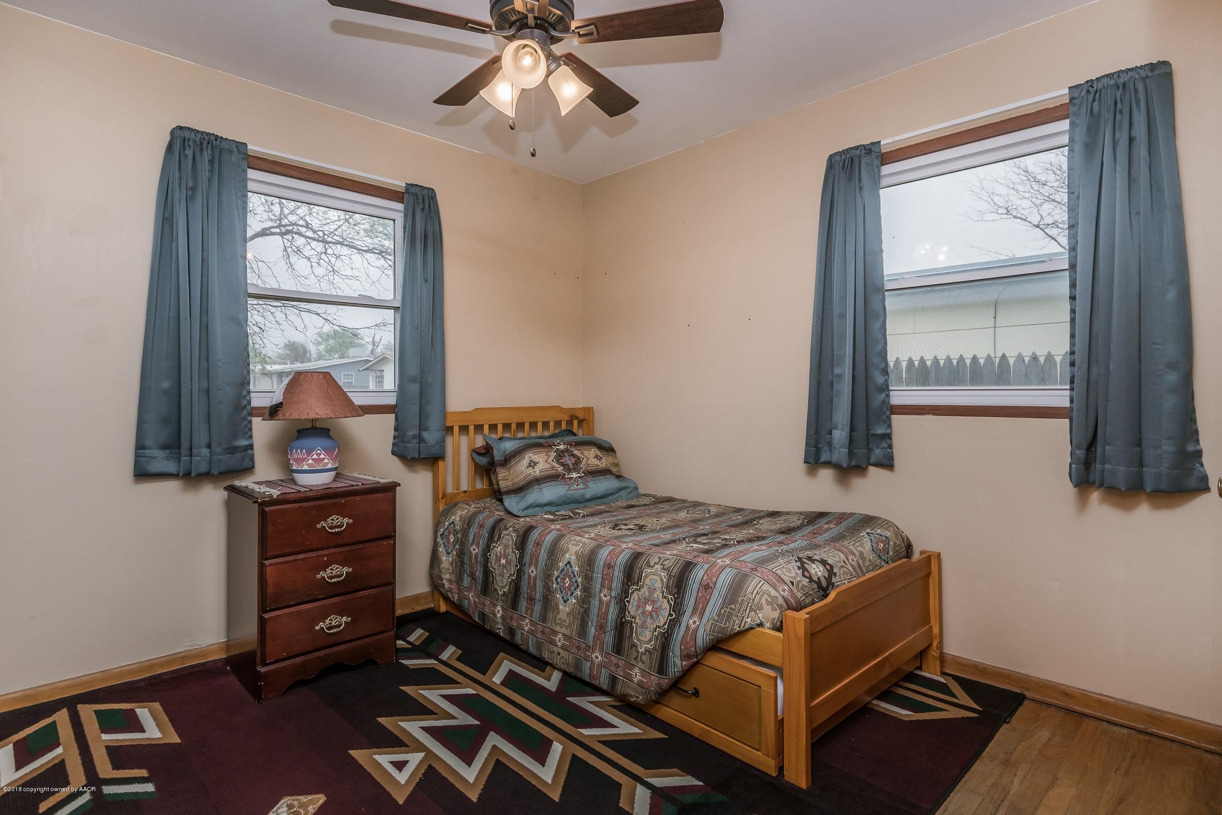 1201 Southwest 48th Avenue Amarillo, TX 79110 - Photo 14 of 18 a bedroom with a bed and wooden floor