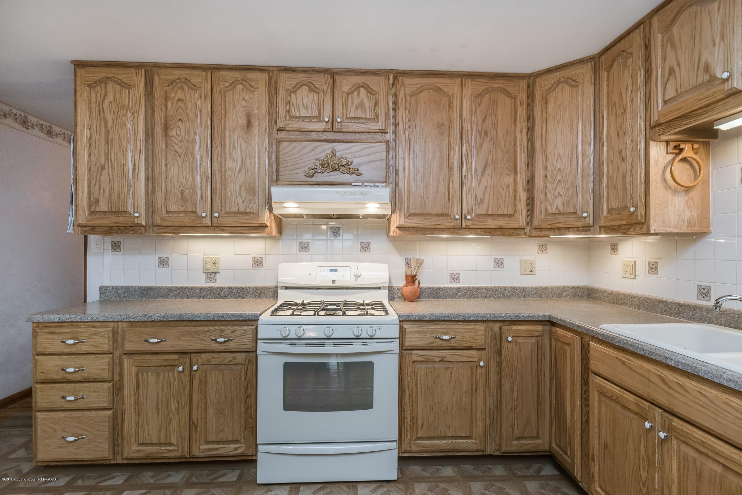 1201 Southwest 48th Avenue Amarillo, TX 79110 - Photo 5 of 18 a kitchen with stainless steel appliances granite countertop a stove and a white cabinets