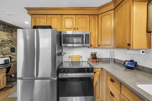 a kitchen with a refrigerator and a stove top oven