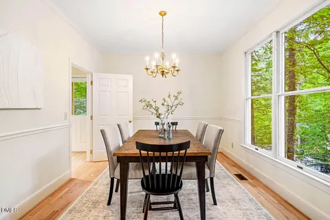 a dining room with furniture a chandelier and wooden floor