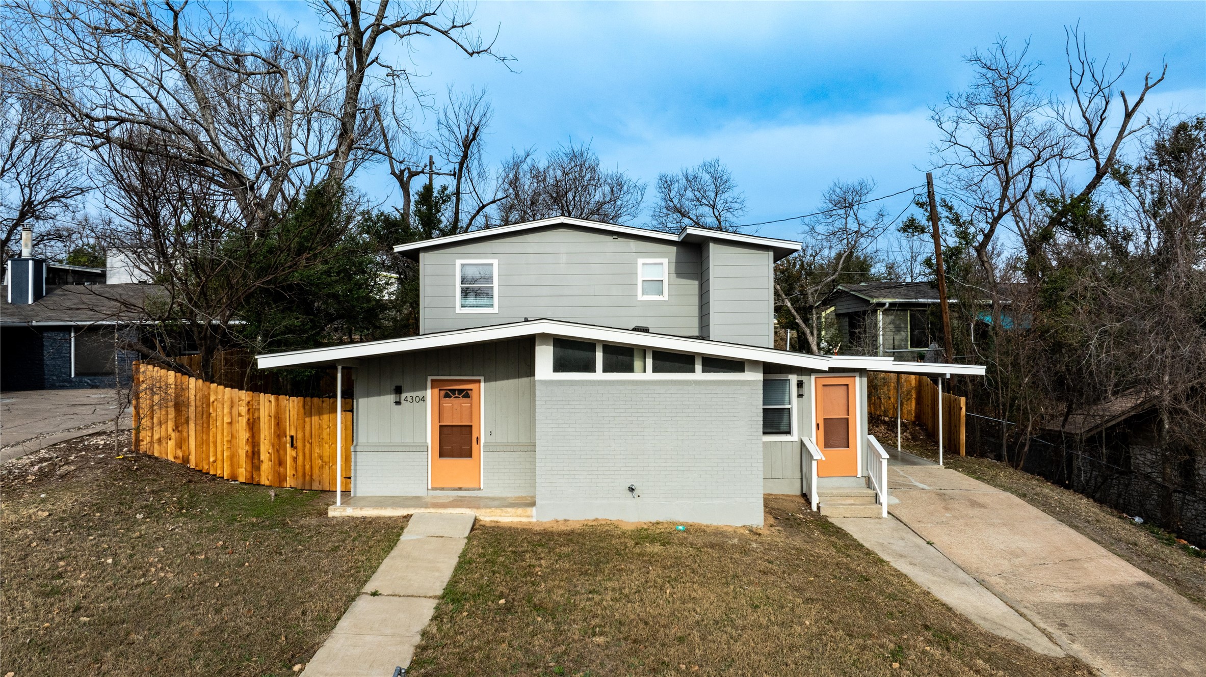View of front of house with brick siding, driveway, and an attached carport