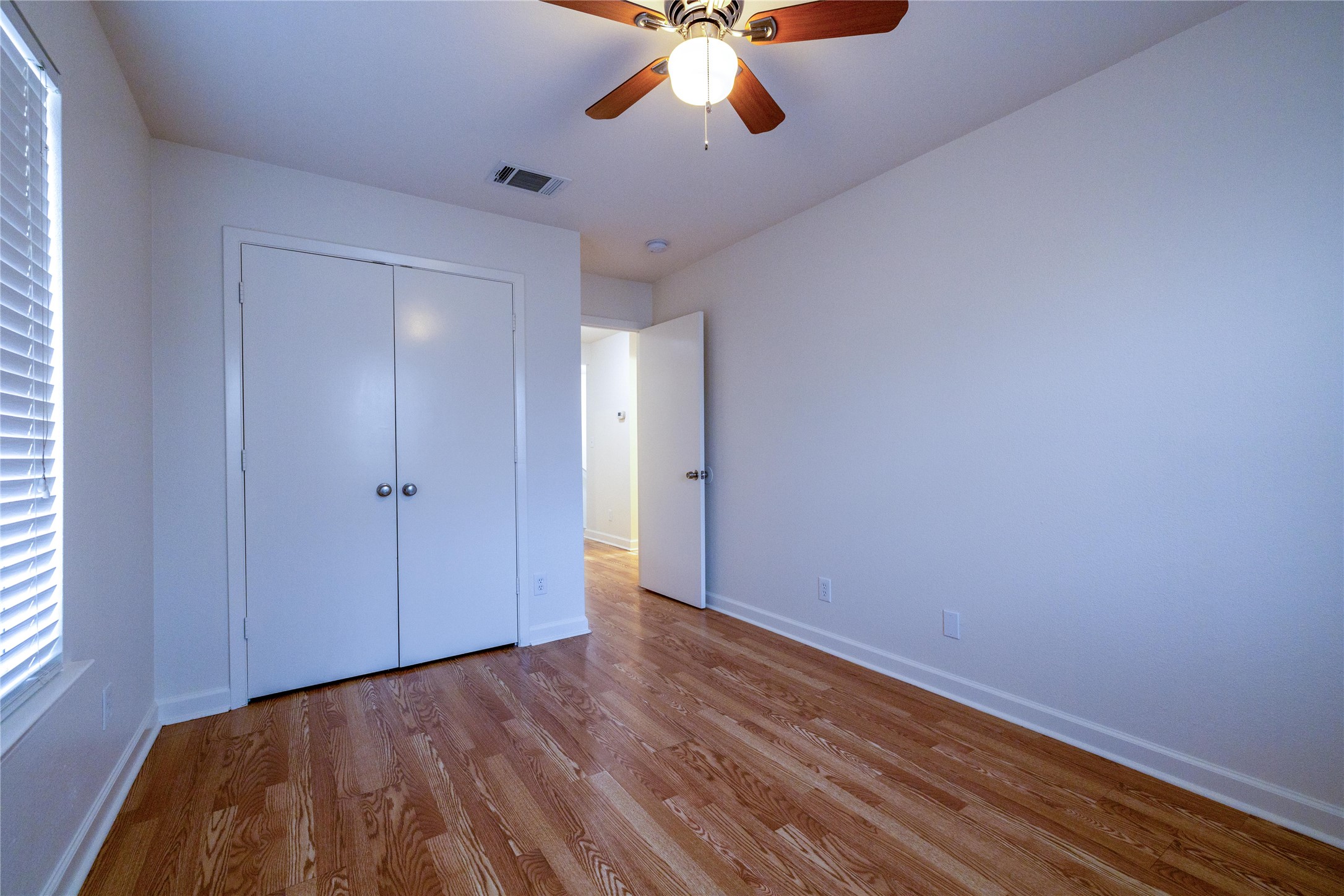 4304 Scottsdale Road Austin, TX 78721 - Photo 14 of 18 Unfurnished bedroom with wood finished floors, ceiling fan, and a closet