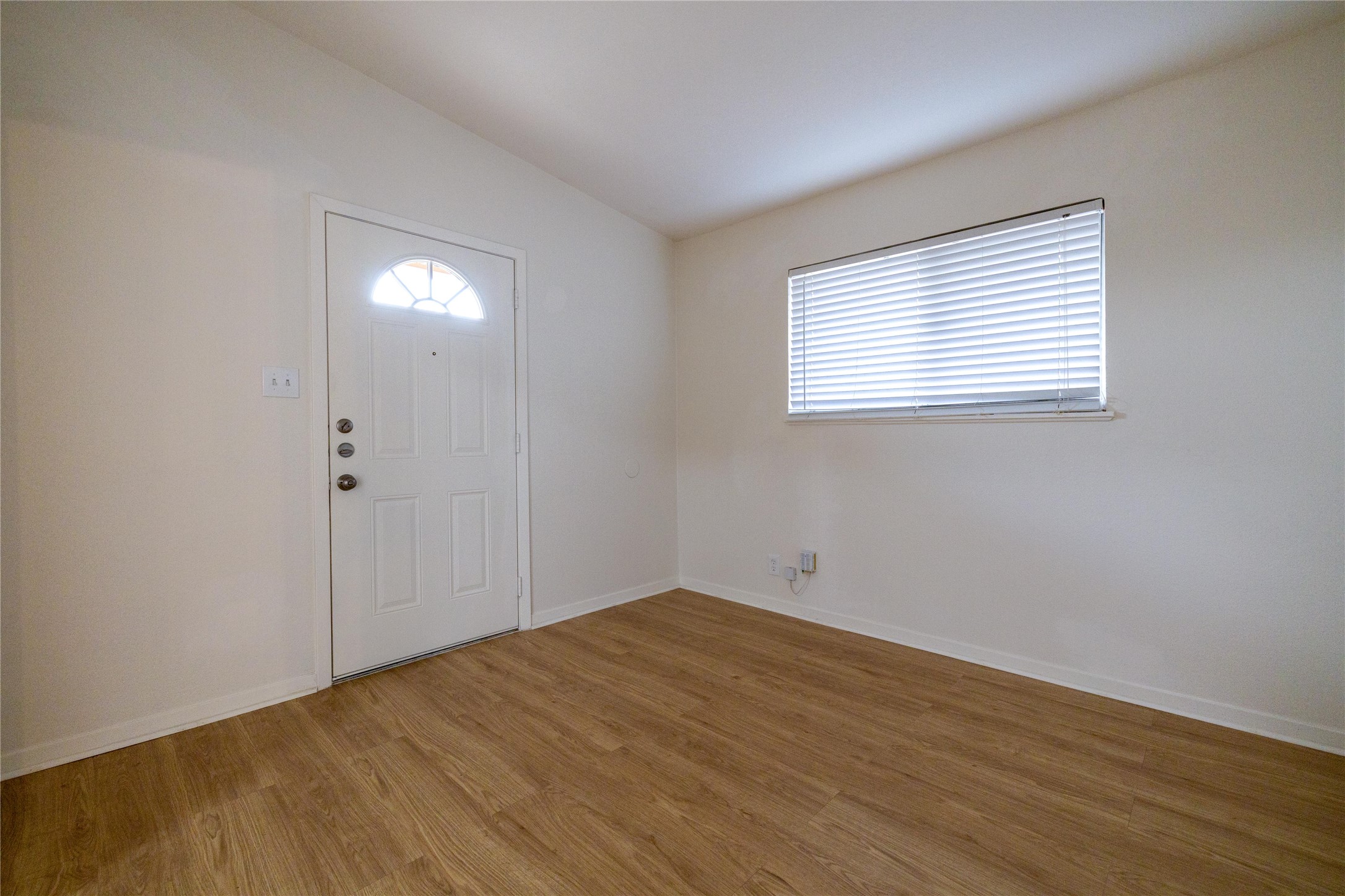 4304 Scottsdale Road Austin, TX 78721 - Photo 3 of 18 Foyer entrance with vaulted ceiling, wood finished floors, and plenty of natural light