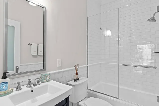 a bathroom with a tub a sink and mirror