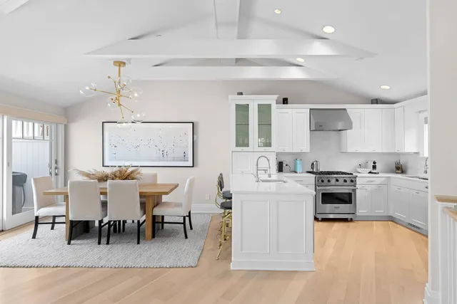 a kitchen with a refrigerator a stove cabinets and chairs