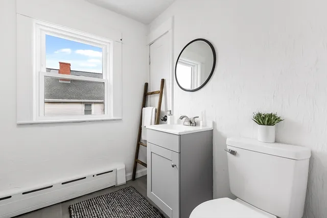 a bathroom with a toilet a sink and a mirror