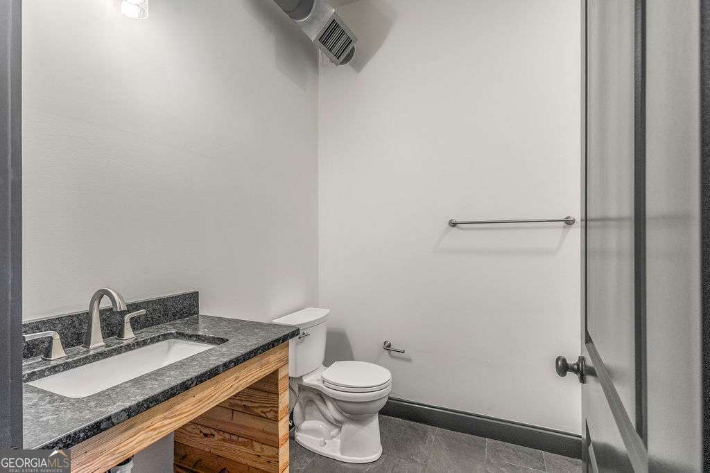 13 Greenville Street South, Unit B Newnan, GA 30263 - Photo 11 of 16 a bathroom with a granite countertop sink toilet and a mirror
