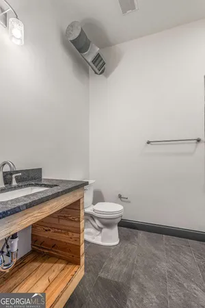 a bathroom with a granite countertop sink toilet and a mirror