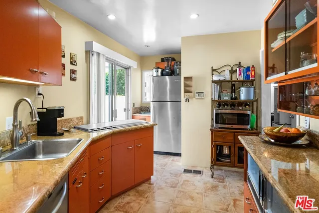 a kitchen with granite countertop a refrigerator and a sink