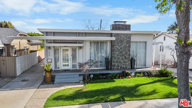 a view of a house with brick walls and a yard with potted plants