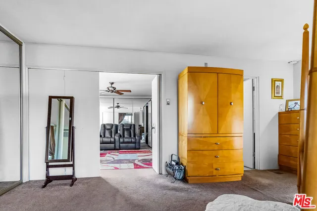 a view of a livingroom with wooden floor and a refrigerator