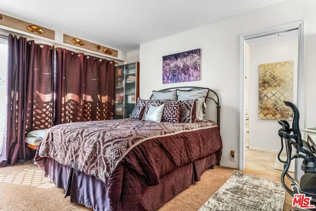 a bedroom with a bed and a painting on the wall