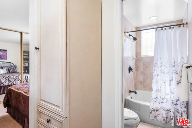 a bathroom with a toilet a shower curtain and a bath tub