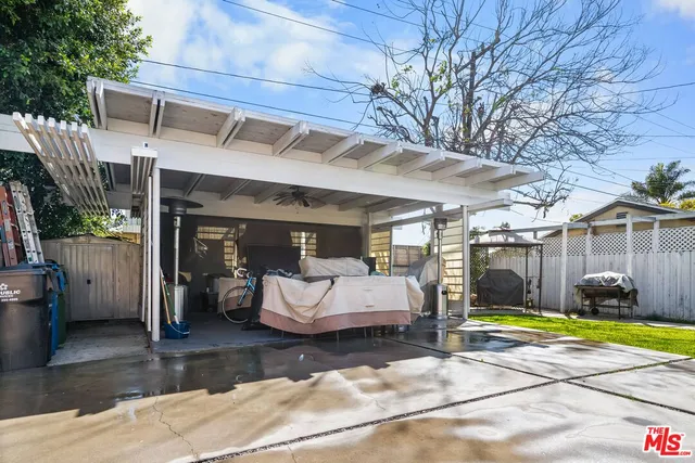 a view of a patio with table and chairs potted plants and a large tree