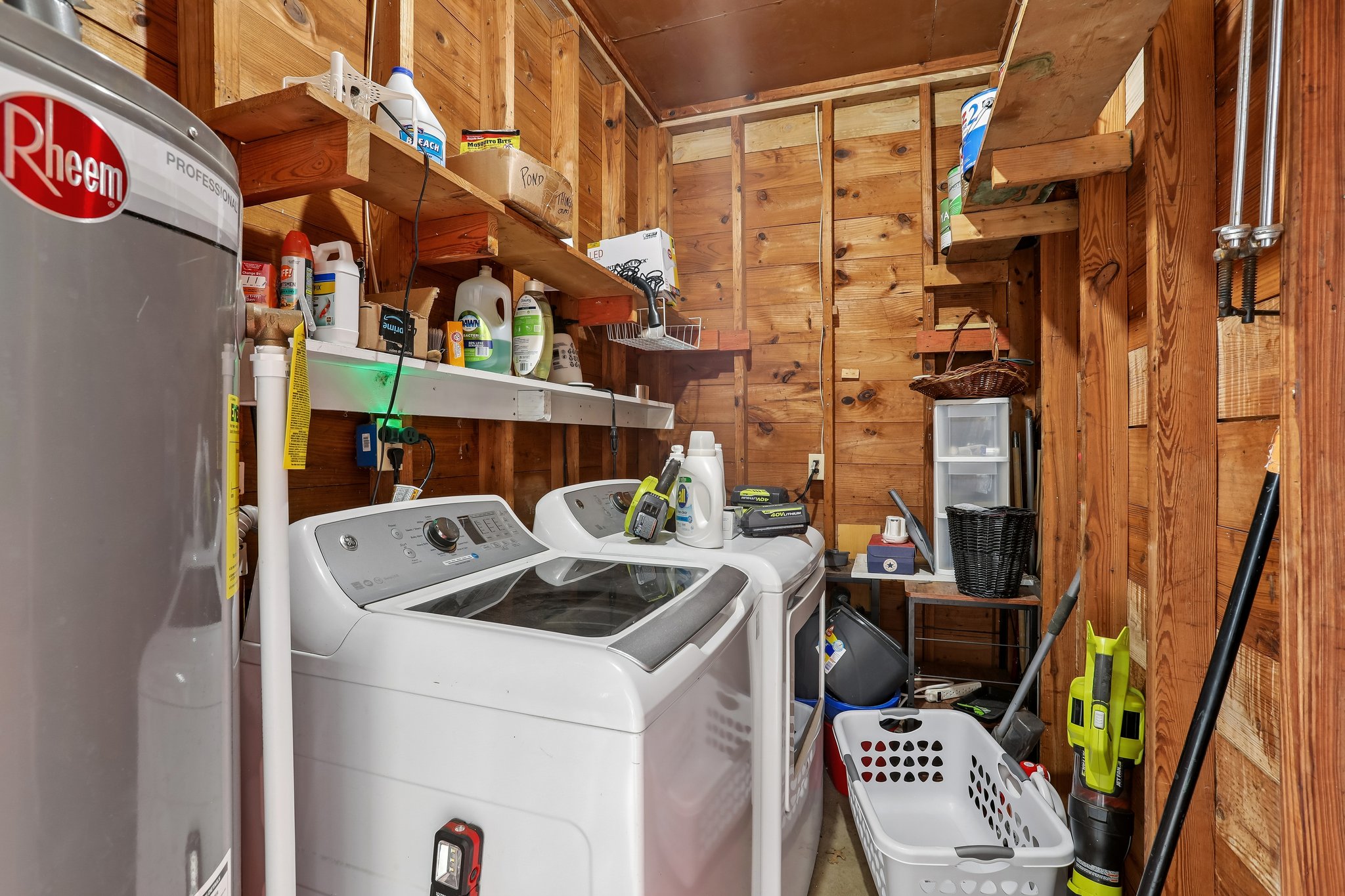 1114 West 2nd Street Elgin, TX 78621 - Photo 21 of 31 A dedicated utility space with robust wood paneling houses essential laundry appliances.
