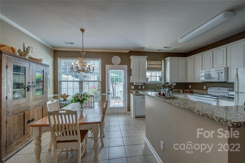 909 Azurine Circle Fort Mill, SC 29708 - Photo 14 of 30 a kitchen with a table chairs refrigerator and cabinets