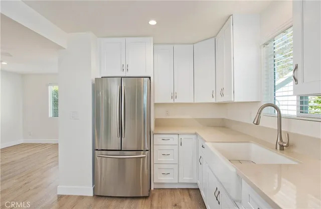 a view of kitchen with stainless steel appliances kitchen island granite countertop a refrigerator and a sink