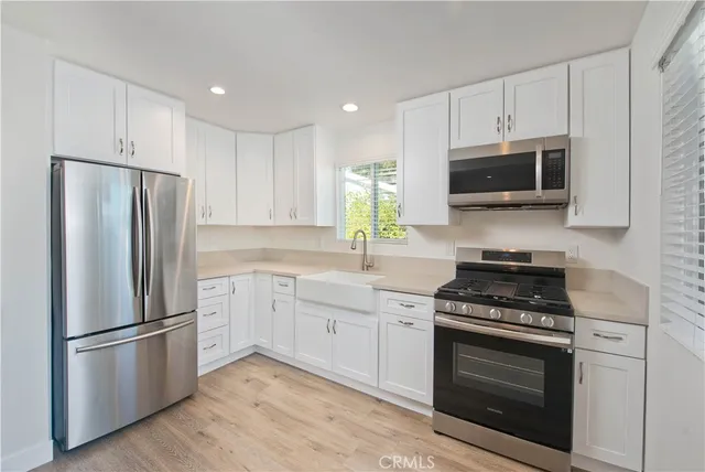 a kitchen with granite countertop a refrigerator and a stove top oven