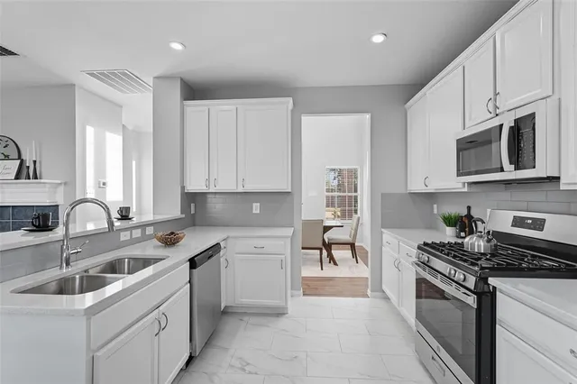 a kitchen with stainless steel appliances granite countertop a sink stove top oven and refrigerator