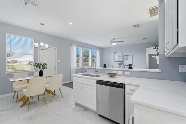 a kitchen with a sink and chairs