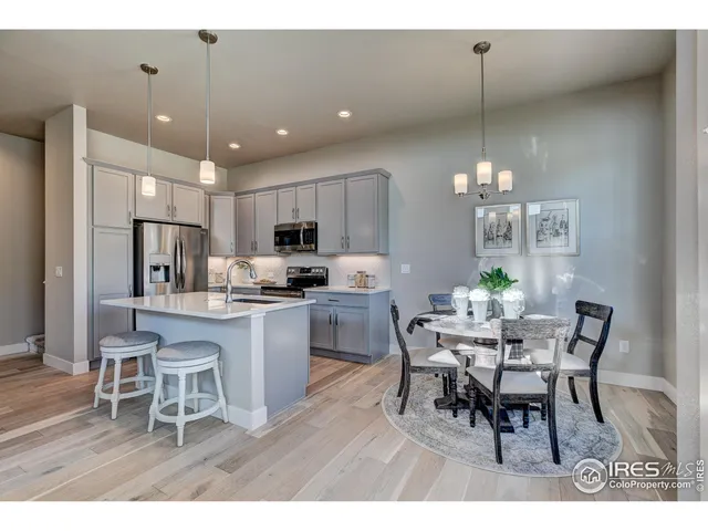 a kitchen with a dining table chairs stainless steel appliances and cabinets