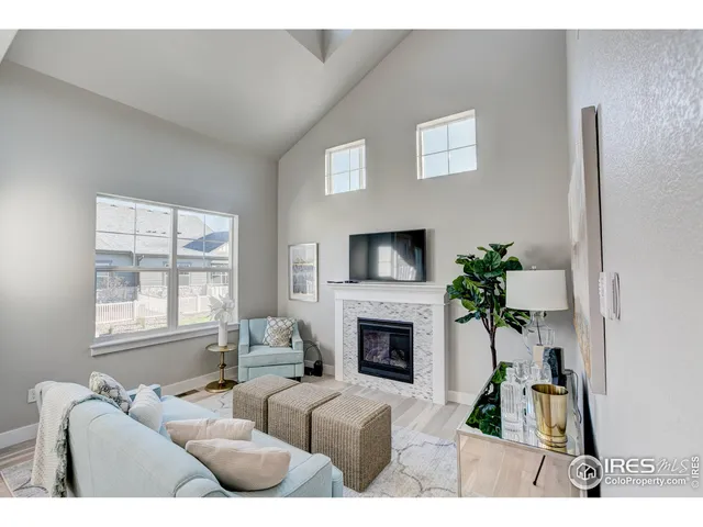 a living room with furniture a fireplace and a potted plant