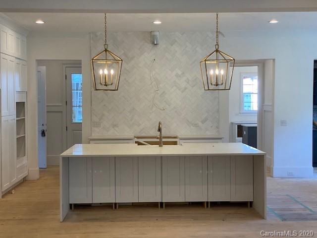 2811 Sharon Road Charlotte, NC 28211 - Photo 1 of 13 a view of a kitchen with granite countertop stainless steel appliances a fireplace and a chandelier