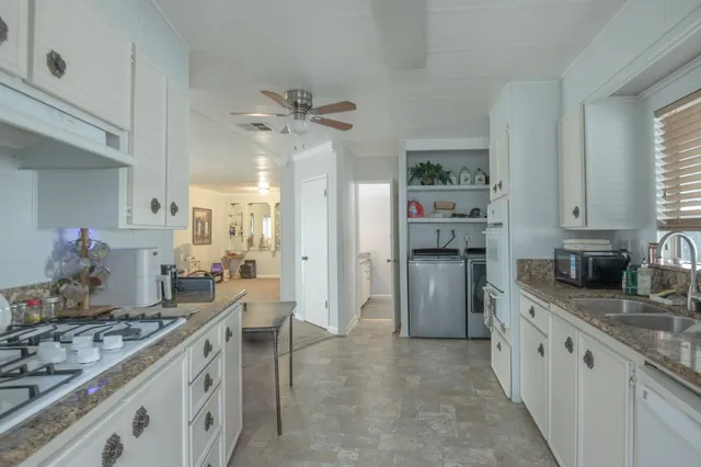 a large kitchen with stainless steel appliances a stove refrigerator and a sink