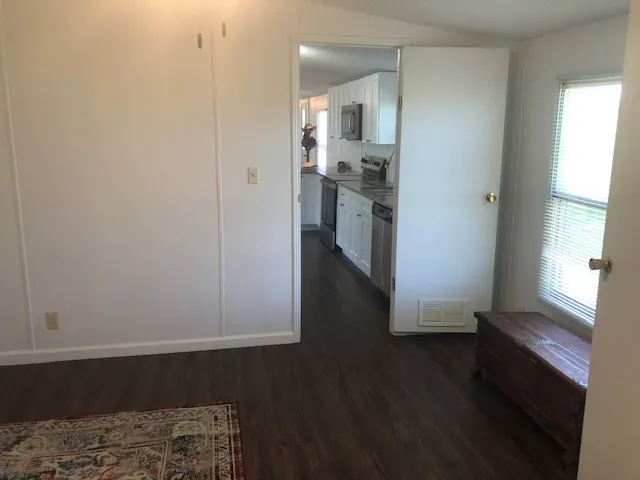 a living room with wooden floor and a window