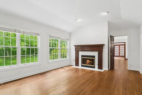 a view of an empty room with a fireplace and a window