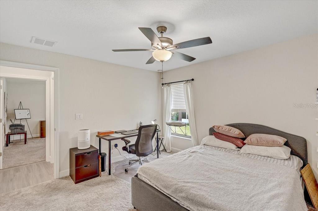 7314 Madrid Road Weeki Wachee, FL 34613 - Photo 24 of 54 a bedroom with a bed and a chandelier