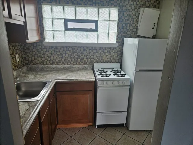 a kitchen with a refrigerator sink and stove