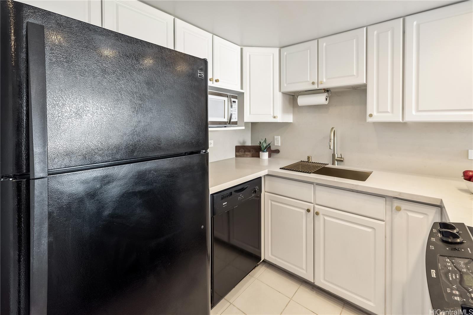 3130 Ala Ilima Street, Unit 21C Honolulu, HI 96818 - Photo 8 of 21 a kitchen with a refrigerator and white cabinets